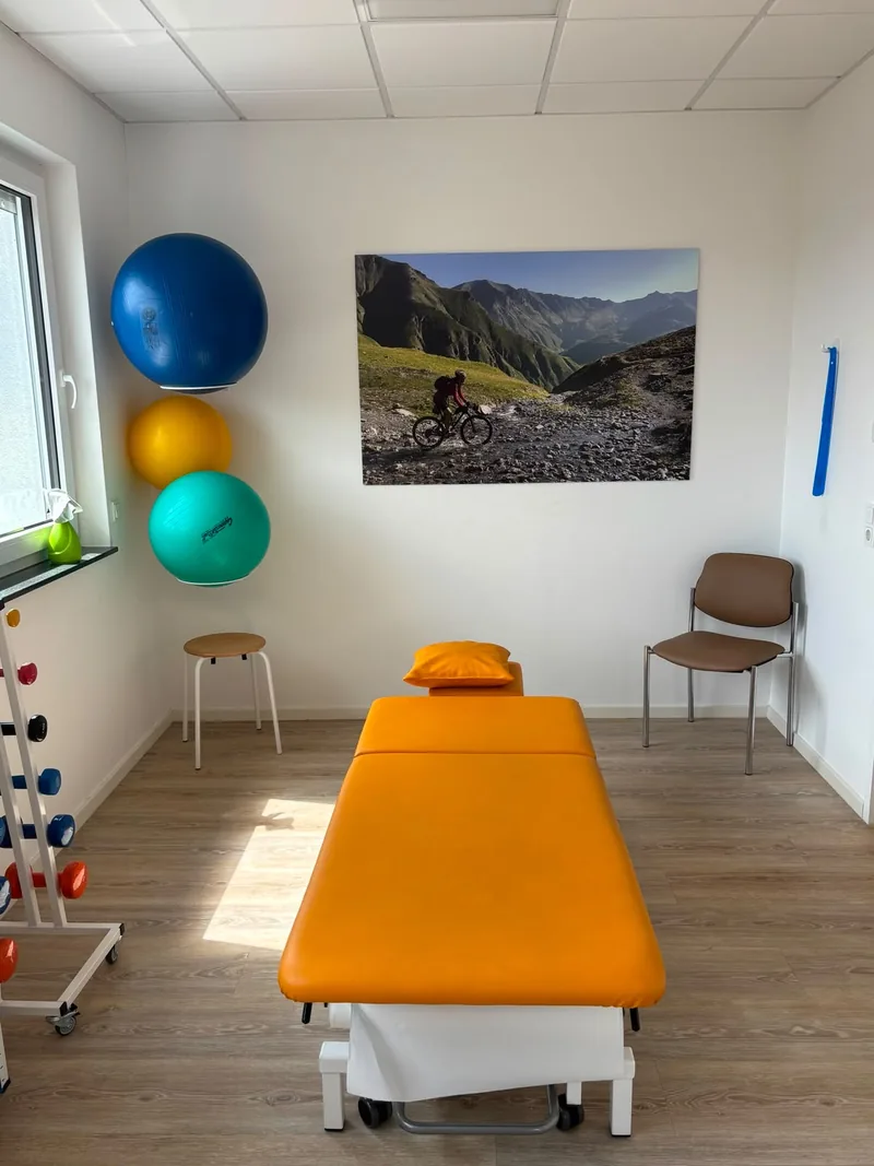Zweites Behandlungszimmer mit Liege, Gymnastikbällen und Kleingeräten